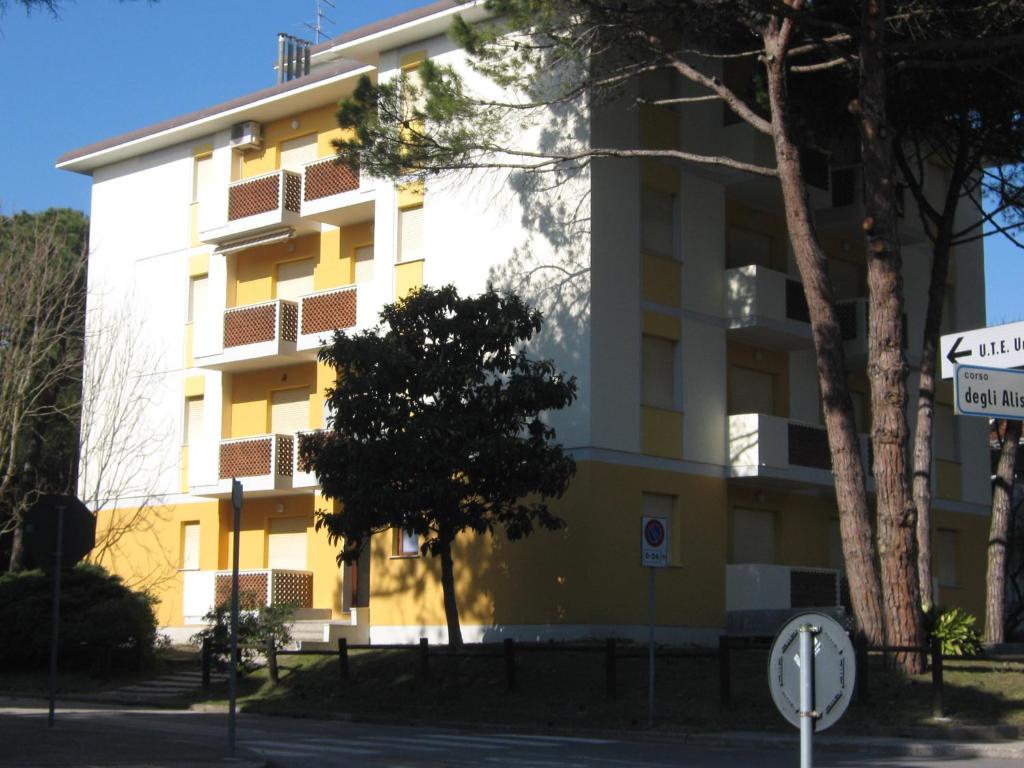 リニャーノ・サッビアドーロにあるCondominio Ginestraの目の前の木々が立ち並ぶ黄白の建物