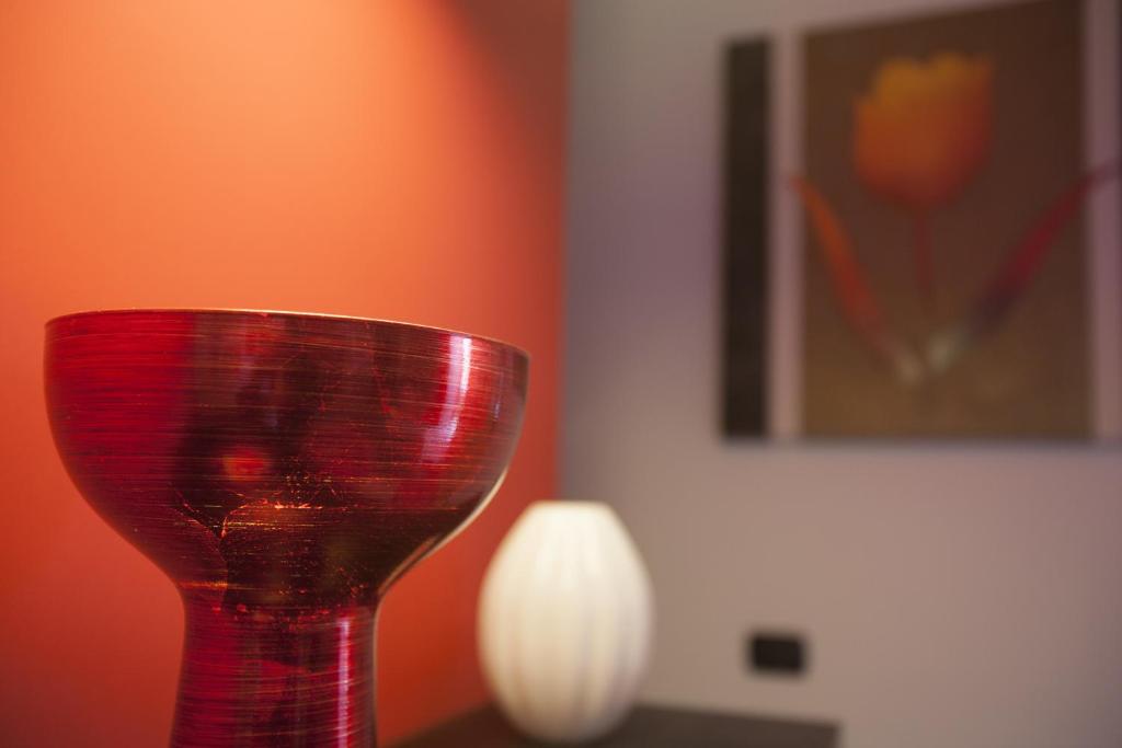 a red glass vase sitting on top of a table at Imperial in Milazzo