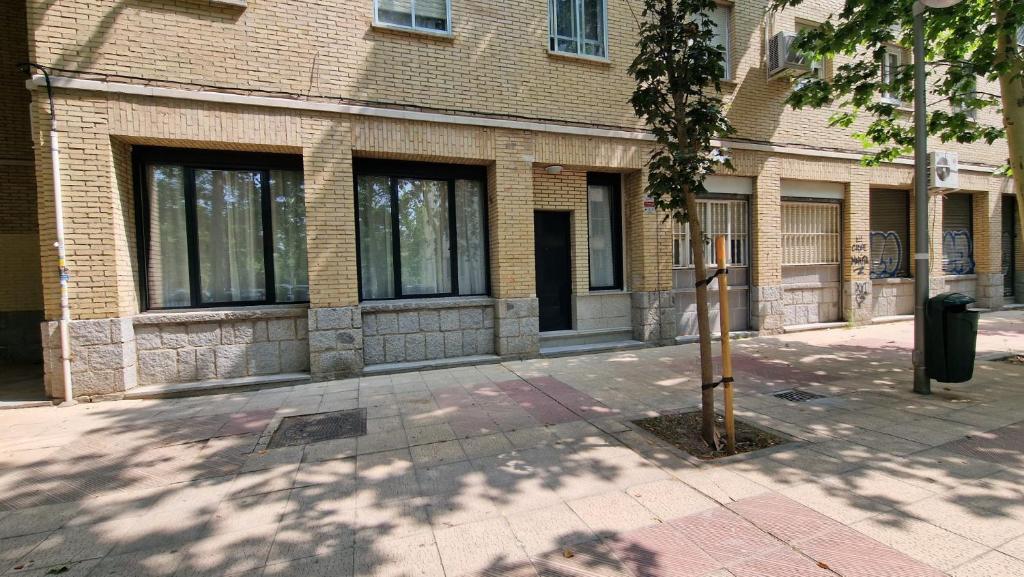 un bâtiment en briques avec un arbre devant lui dans l'établissement La Promesa, à Madrid