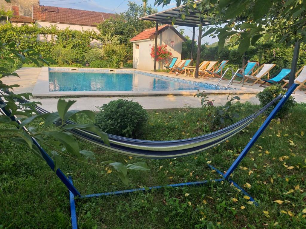 a hammock in a yard next to a swimming pool at Rustic village in Rijeka Crnojevića