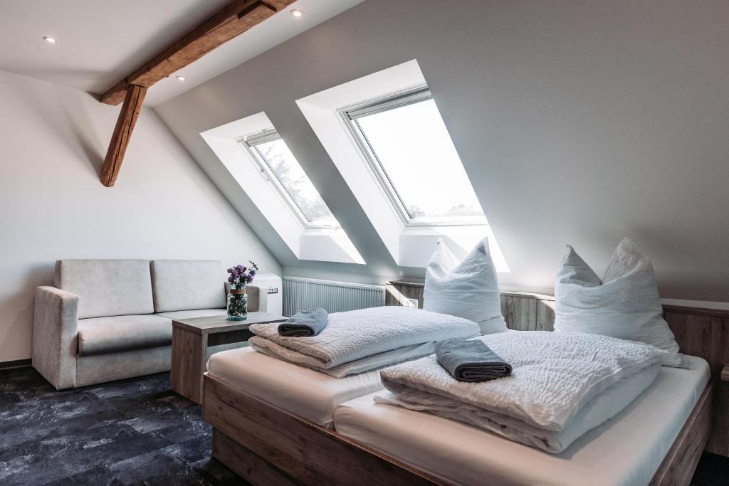 a attic bedroom with a bed and a chair at Heberer Hof in Schneverdingen