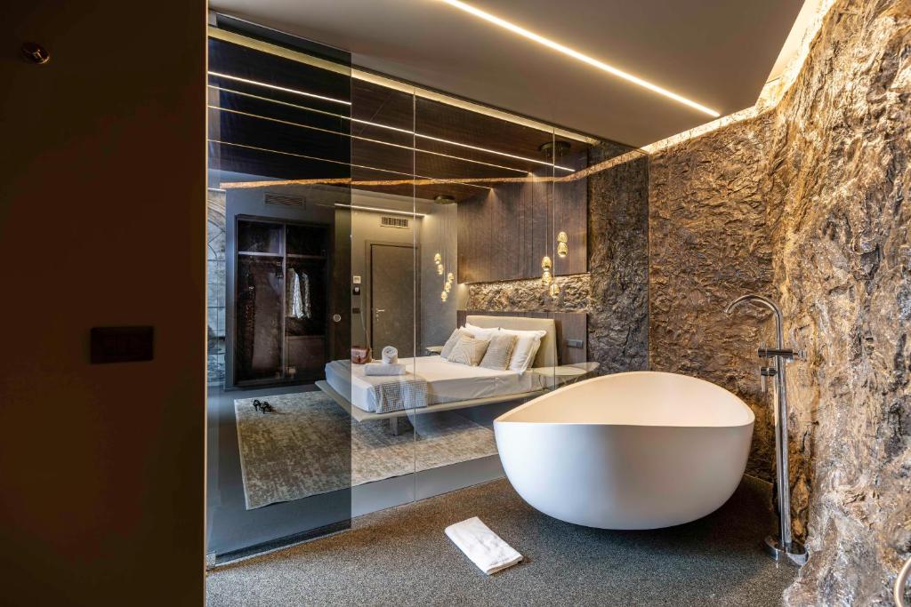 un bagno con vasca e un letto in una camera di Boutique Marconi a Quartu SantʼElena