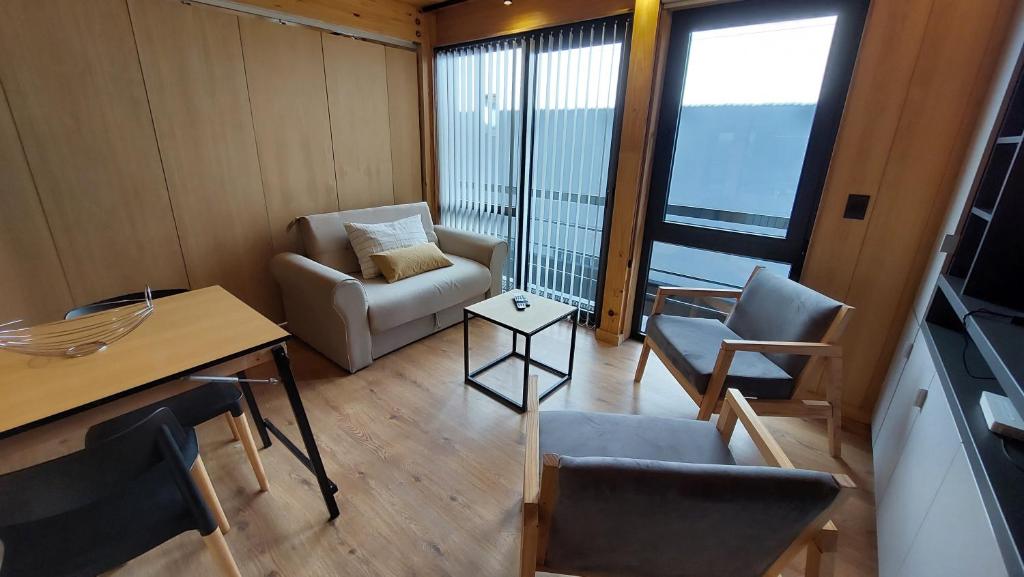 sala de estar con sofá, sillas y mesa en Departamento de diseño, muy bien ubicado en el centro de SMA 13V5 en San Martín de los Andes