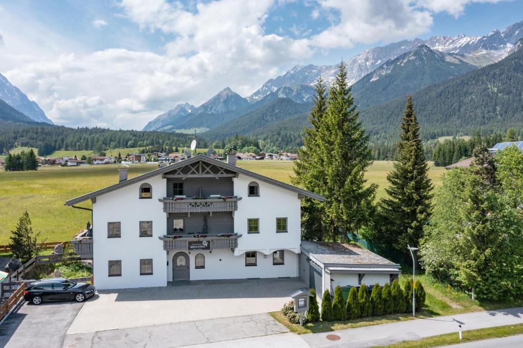 a large white house with mountains in the background at Karwendel Berglodge in Leutasch