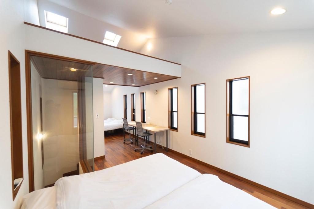 1 dormitorio con 1 cama, escritorio y ventanas en Minato-ku - House - Vacation STAY 14528, en Tokio