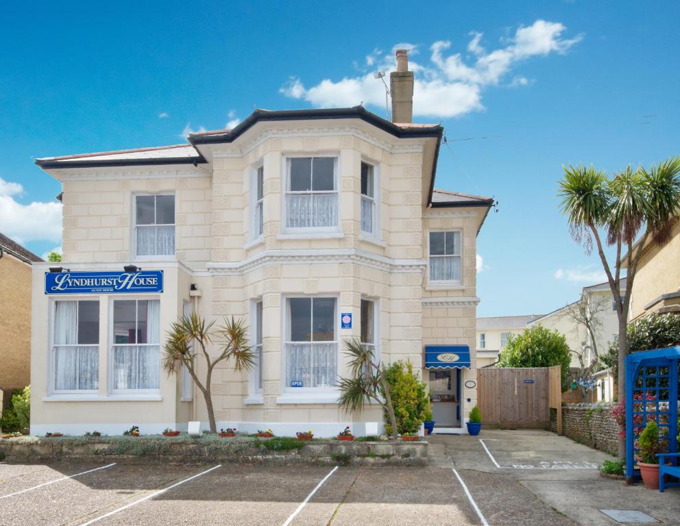 una casa blanca con palmeras en un aparcamiento en Lyndhurst House, en Sandown