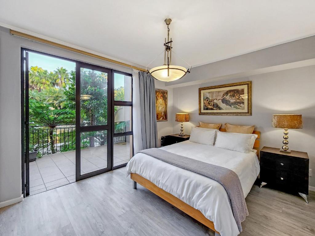 1 dormitorio con 1 cama grande y balcón en Heated pool, Private garden, self check-in, en Ciudad del Cabo