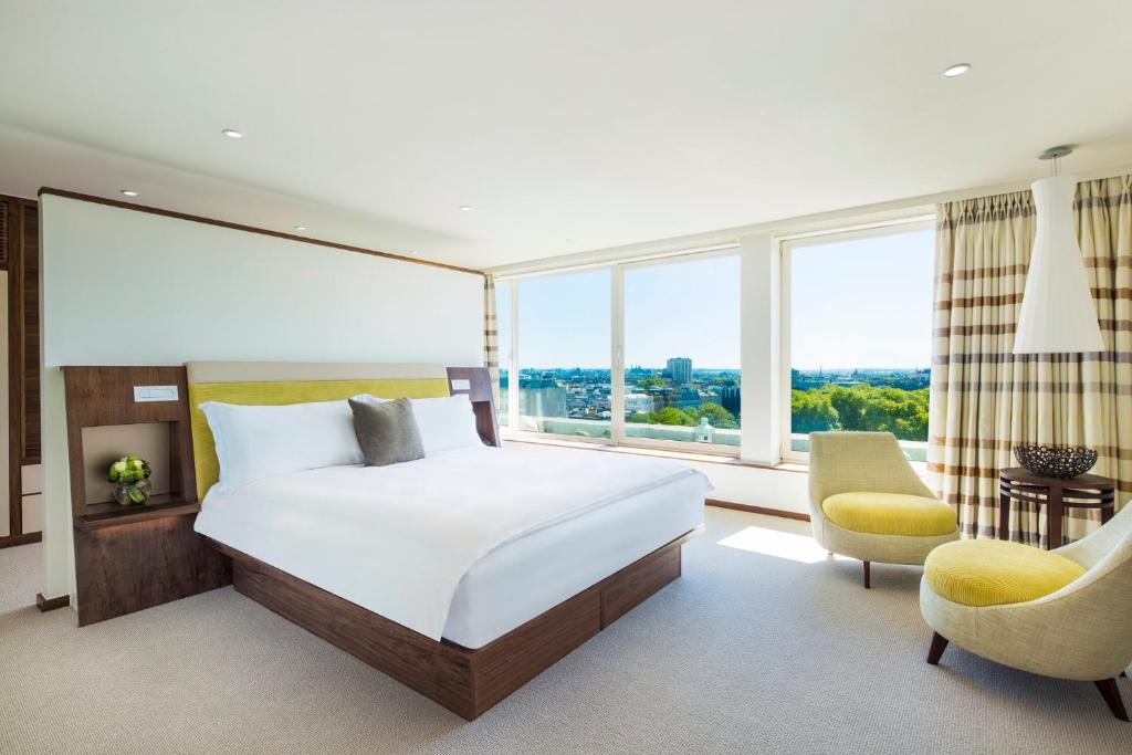 ein Schlafzimmer mit einem Bett und einem großen Fenster in der Unterkunft COMO Metropolitan London in London