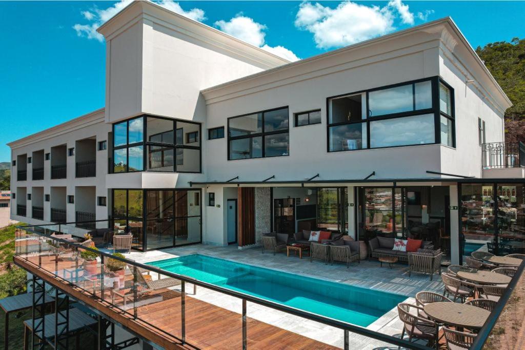 an exterior view of a house with a swimming pool at Vista do Lago Hotel in Capitólio