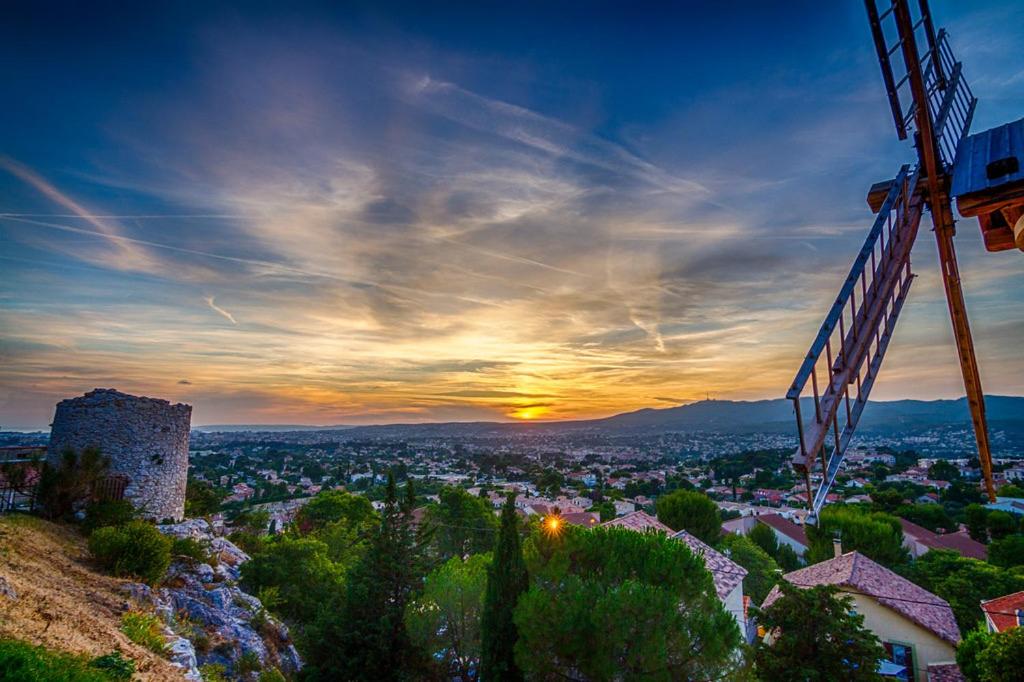 a view of a city at sunset with a crane at Au charme provençal in Allauch