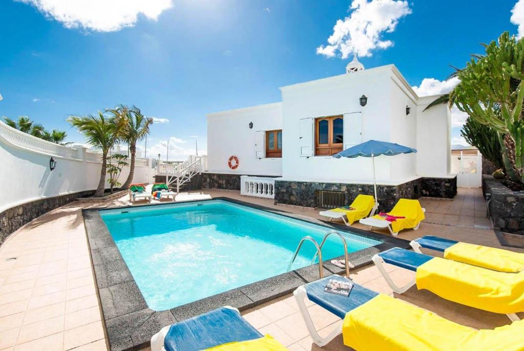 een villa met een zwembad en een huis bij Villa Ramos Dos in Puerto Calero