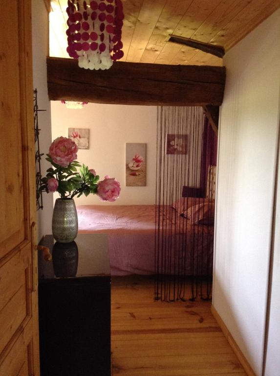 a hallway with a vase with flowers on a table at L&#39;écrin - Chambres d&#39;hôtes au calme et au vert 