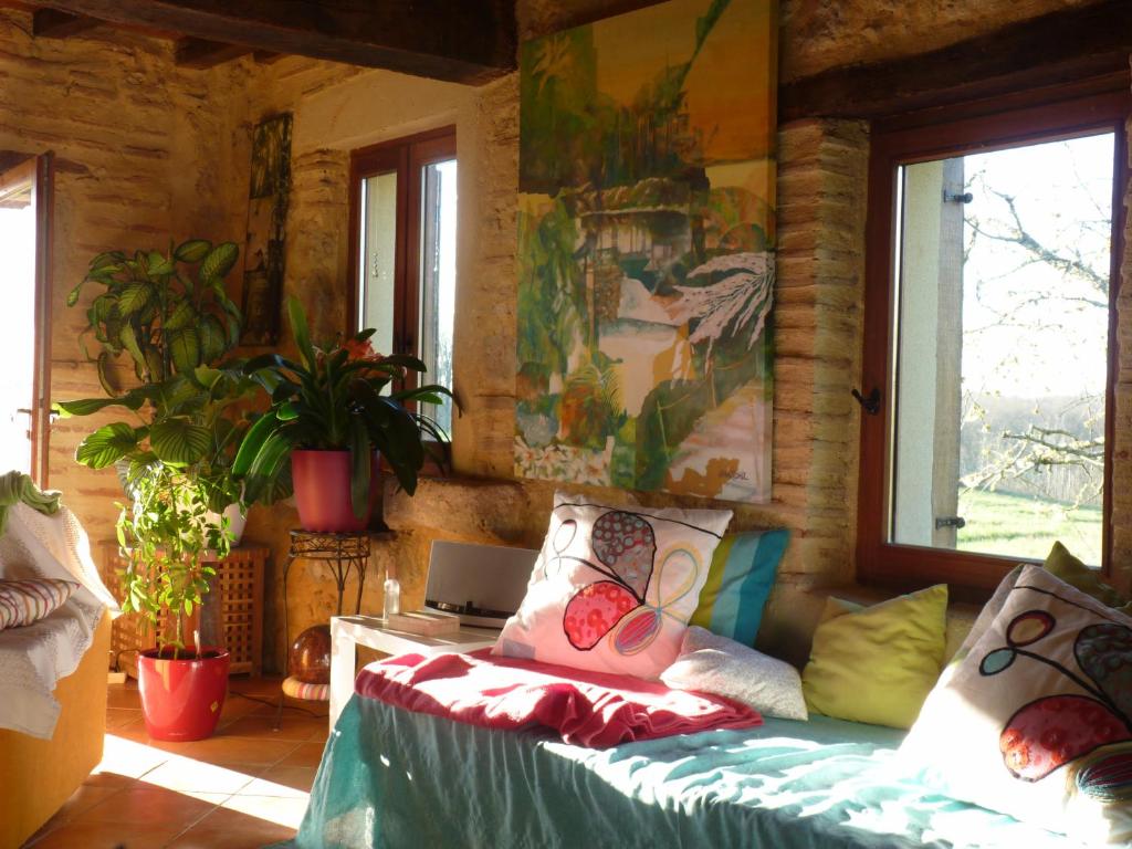 a room with a couch and a table with a laptop at L&#39;écrin - Chambres d&#39;hôtes au calme et au vert 