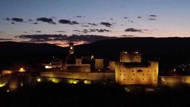 uma cidade iluminada à noite com um castelo em Hostal La Trucha Sanabria em Puebla de Sanabria