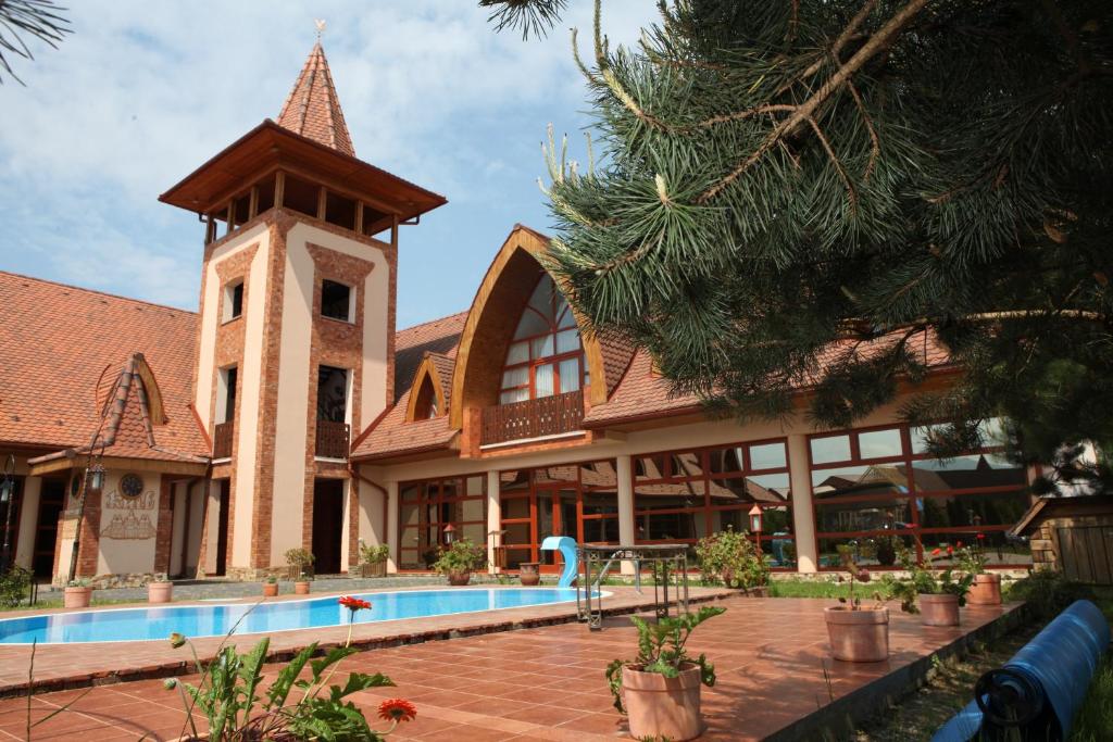 a building with a clock tower and a swimming pool at Publo Spa Hotel in Vyshkove