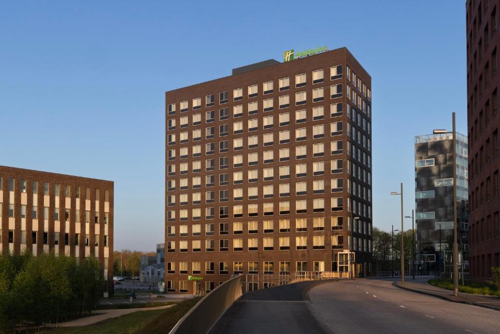 een hoog gebouw op een straat in een stad bij Holiday Inn - Eindhoven Airport, an IHG Hotel in Eindhoven