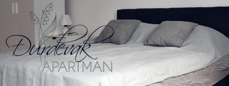 a bedroom with a white bed with the words outpatient apartmentarma at Apartman DJURDJEVAK in Vršac