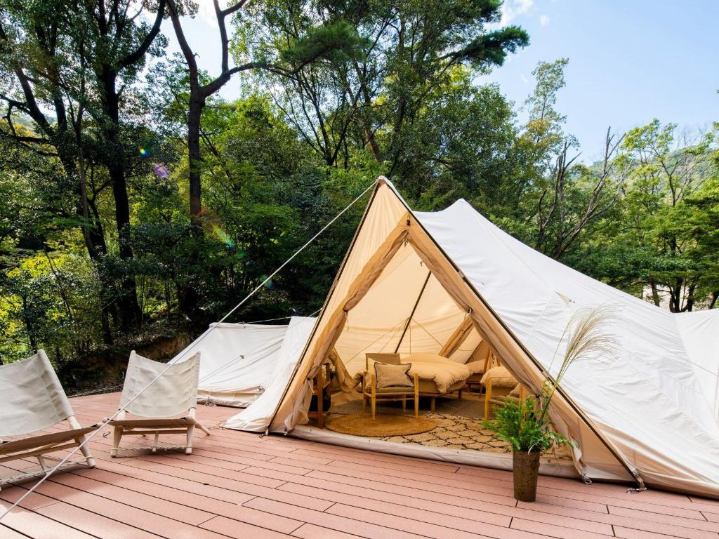 a canvas tent with chairs and chairs on a wooden deck at Nordisk Hygge Circles Ugakei - Vacation STAY 75257v in Komono