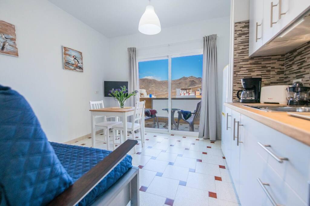 a kitchen with a counter and a table with a view at Tindaya in Las Playas