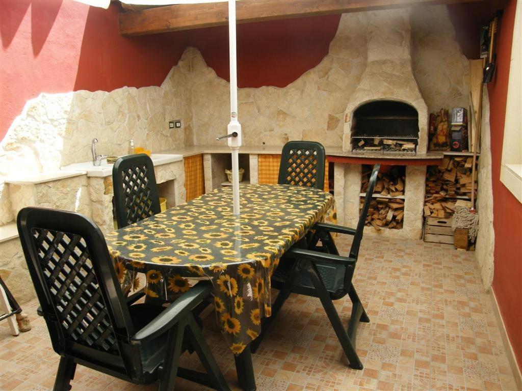 ポッツァッロにあるOasi del Sud Monolocale Stefyのキッチン(テーブル、椅子、オーブン付)