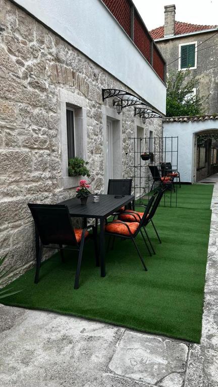 patio ze stołem i krzesłami na zielonym trawniku w obiekcie Grošovi Dvori w mieście Opuzen