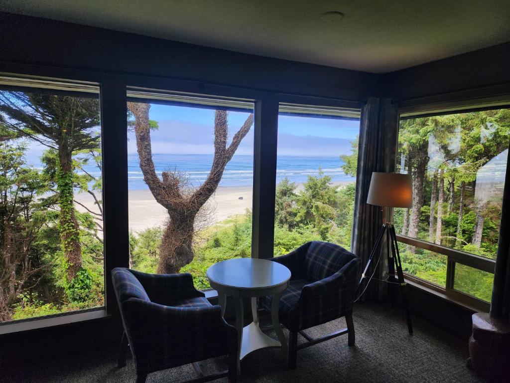 een kamer met een tafel en stoelen en uitzicht op de oceaan bij Ocean Crest Resort in Moclips