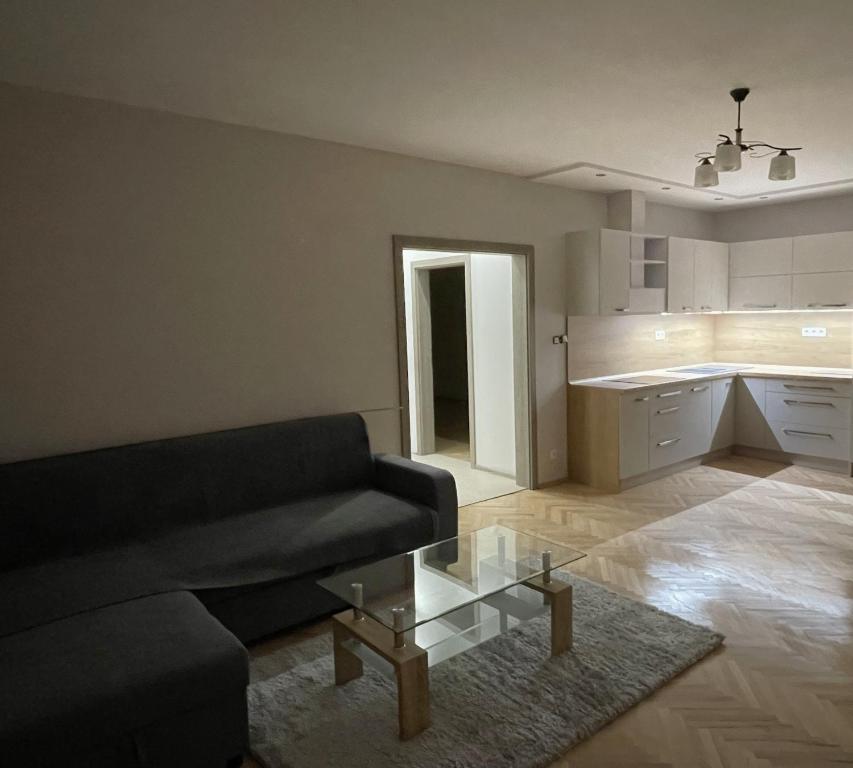 a living room with a couch and a glass coffee table at Apartmán Košice in Košice