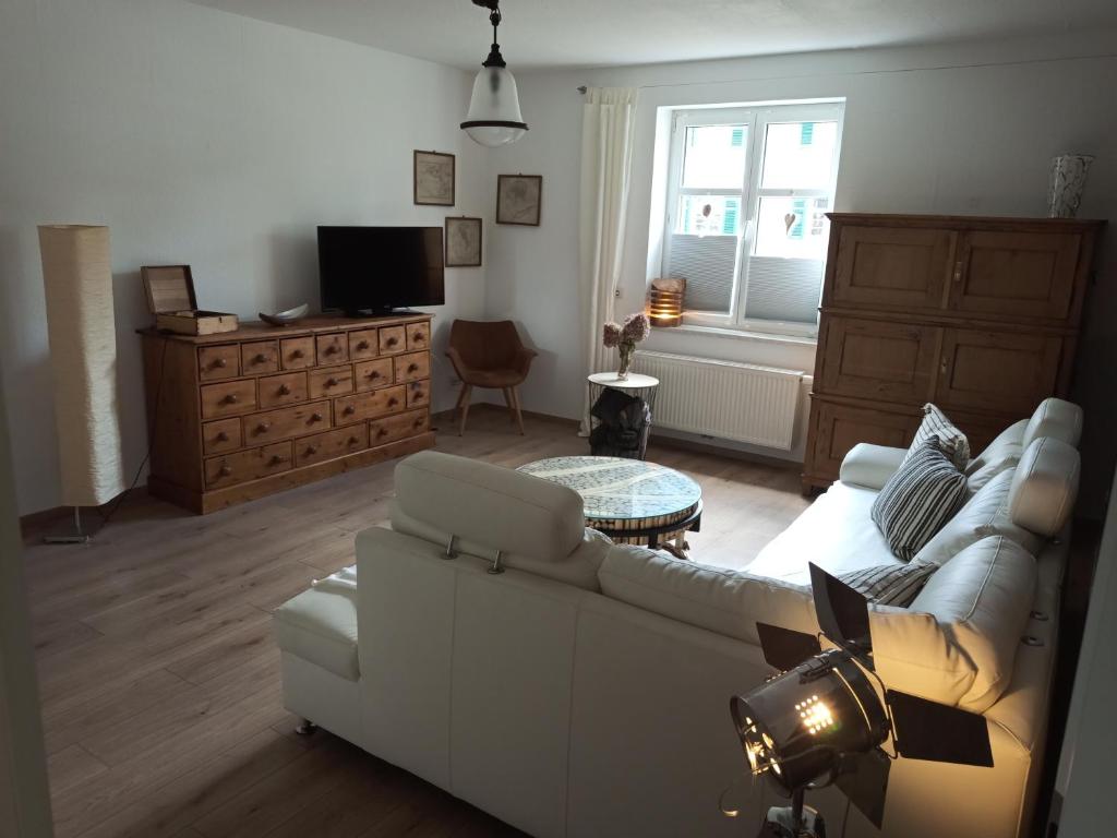 een woonkamer met een witte bank en een tafel bij Lausitzer Auszeit in Laubusch