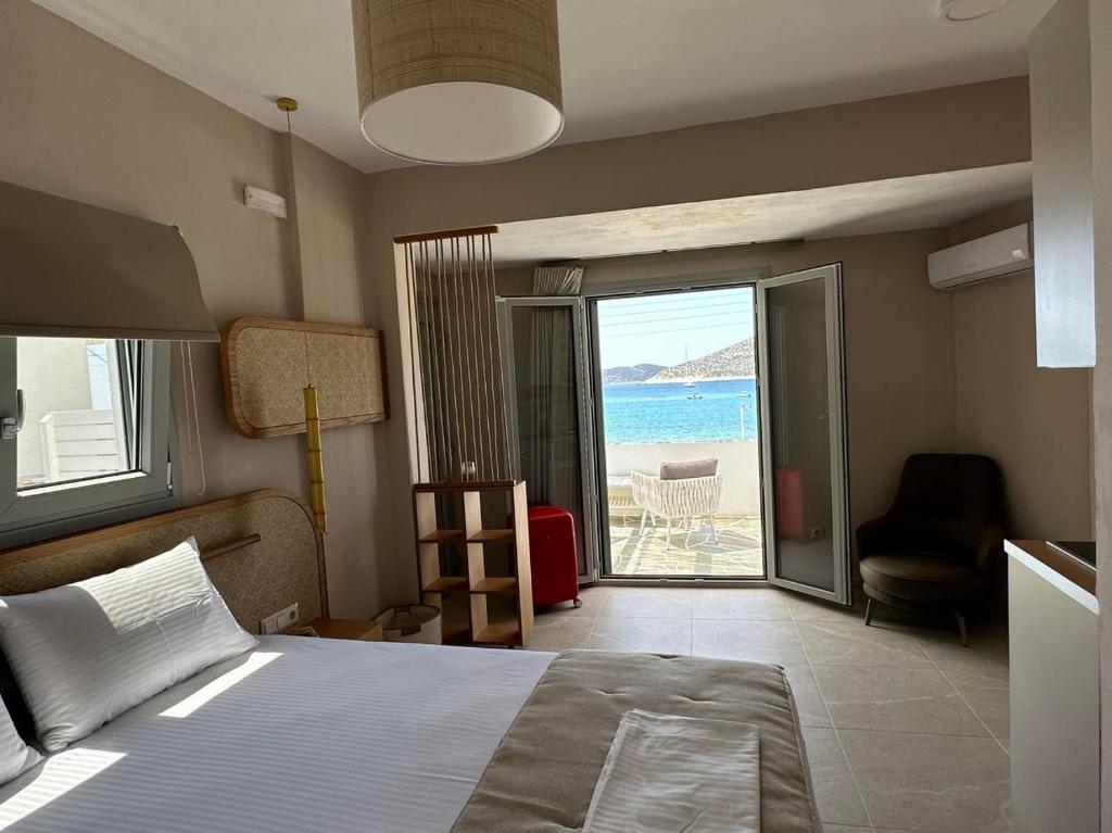 1 dormitorio con cama y vistas al océano en Lemonia Rooms, en Platis Yialos Sifnos