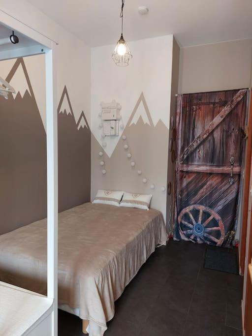 une chambre avec un lit avec une porte en bois et des montagnes dans l'établissement Studio à la montagne en rez-de-jardin, à Montclar