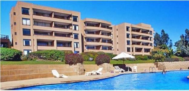 a swimming pool in front of a large apartment building at Hermoso departamento de 2 dormitorios con una vista maravillosa in Valparaíso