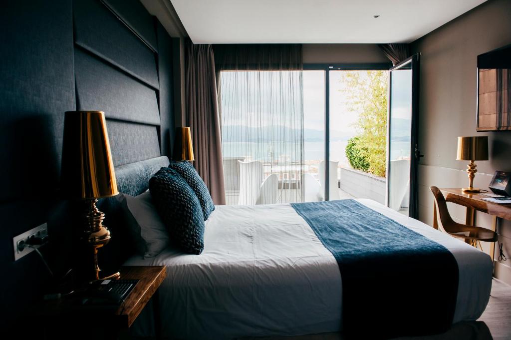 a bedroom with a bed with a view of the ocean at Hotel Art Santander in Santander