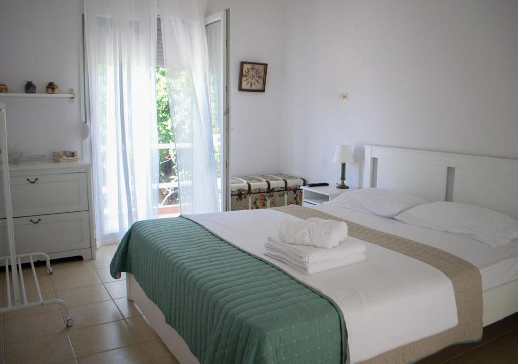 1 dormitorio con 1 cama con manta verde y blanca en Lemon House, en Neo Klima
