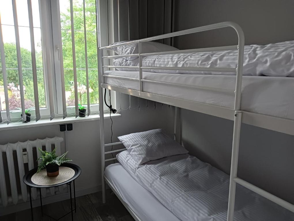 a room with two bunk beds and a small table at Apartamenty Oświęcim klimatyzacja air-conditioned in Oświęcim