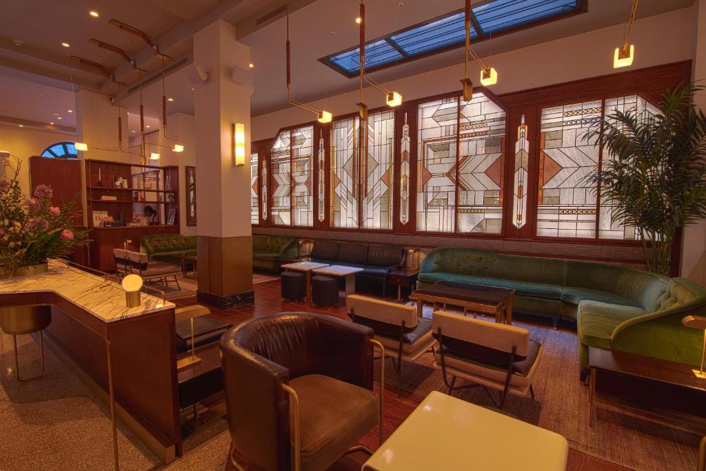 - un hall avec des chaises, des tables et des fenêtres dans l'établissement The Evelyn NoMad, à New York