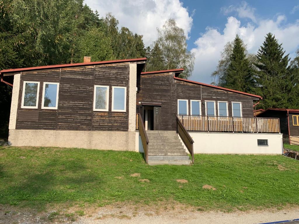 uma casa de madeira com uma escada em frente em Chaty Dobrá Voda 86 em Horní Planá