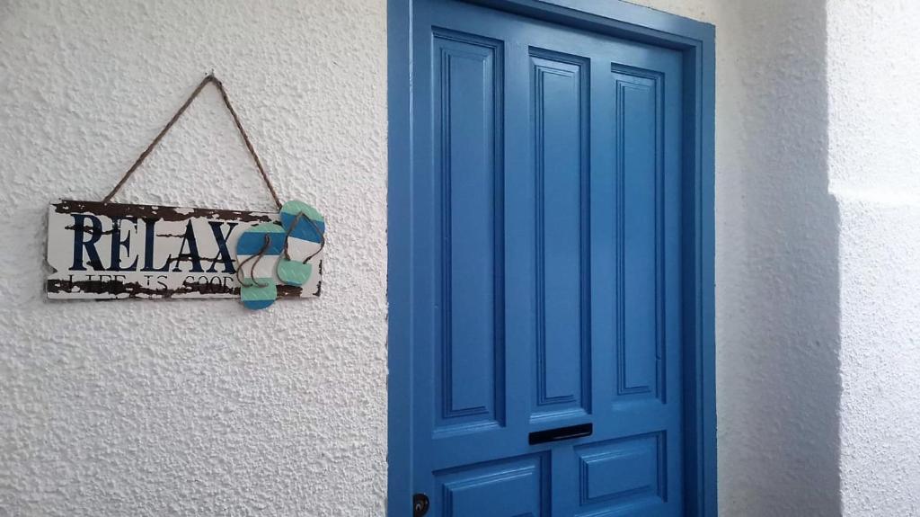 una puerta azul y una señal en el lateral de un edificio en Apartamento Relax Mojácar, en Mojácar