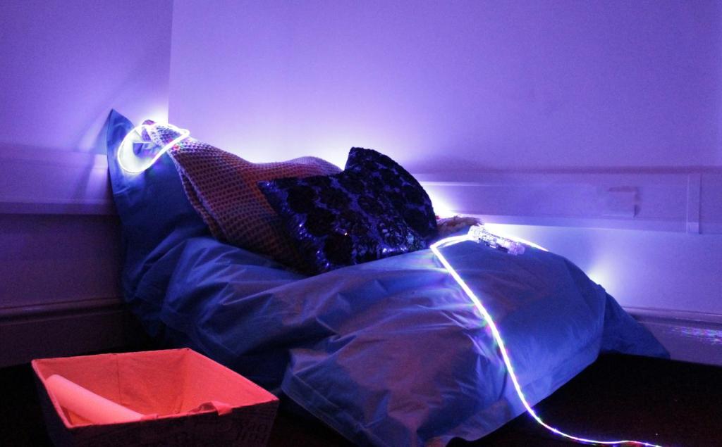 a bed in a room with purple lights at Gwesty Seren Hotel in Blaenau-Ffestiniog