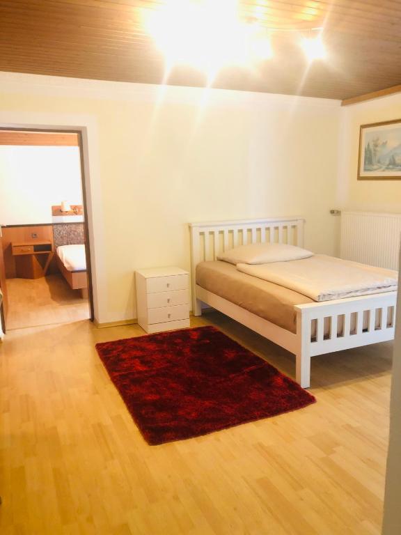 a bedroom with a bed and a red rug at Holmes Café & Pension in Engelhartszell