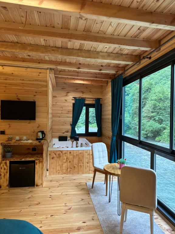 a living room with a table and chairs in a cabin at Kiana Bungalov in Ardeşen