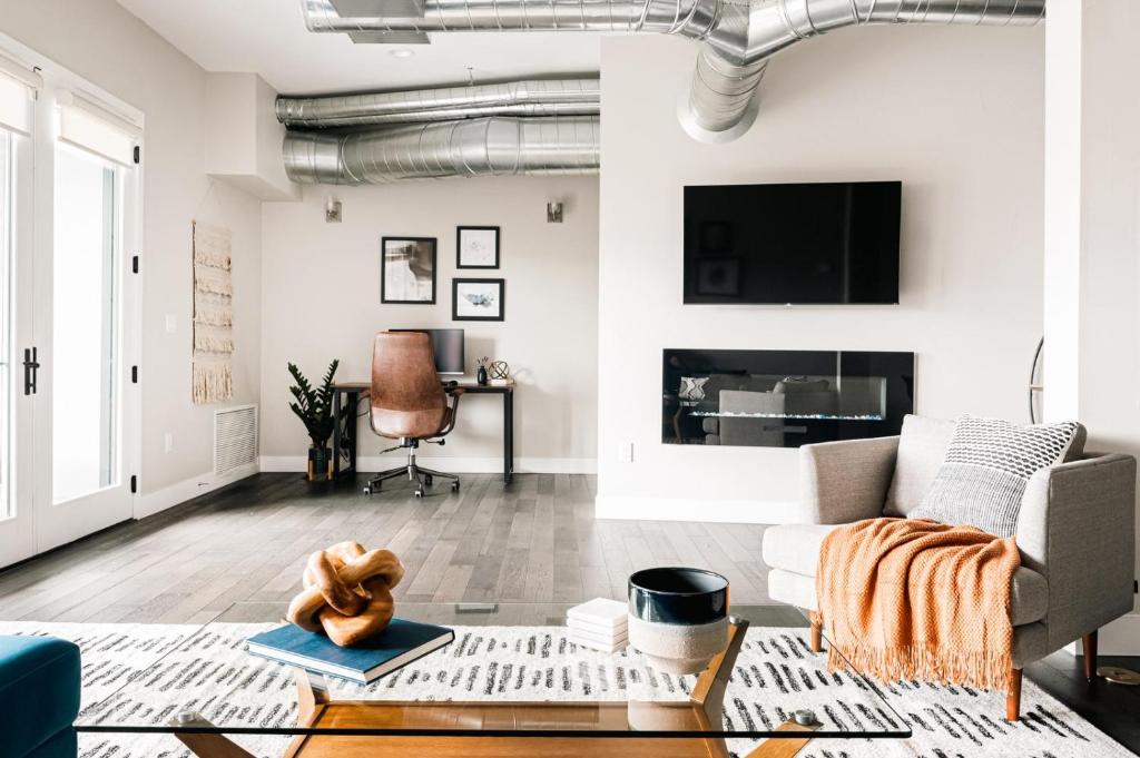 a living room with a couch and a tv at Modern Industrial Loft - Center of RiNo Art District in Denver