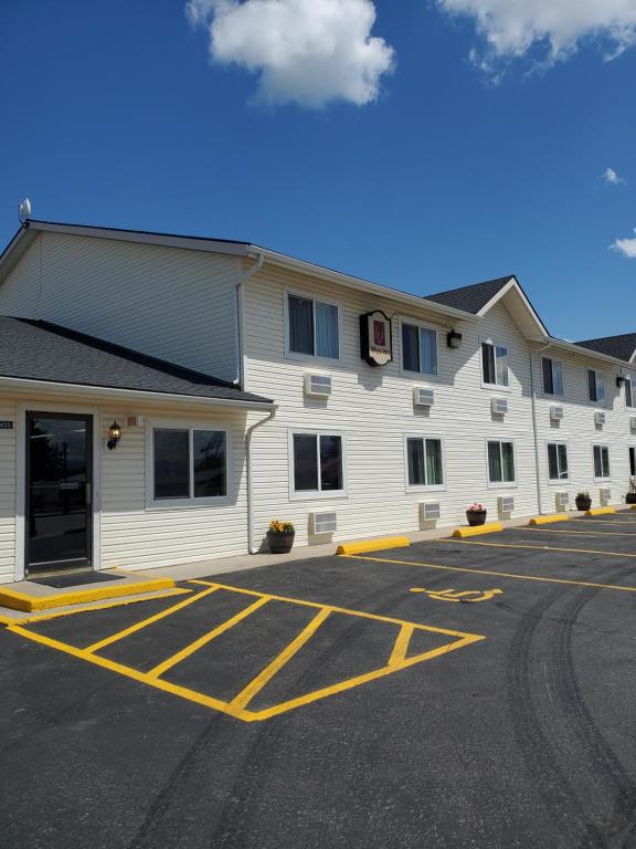 un gran edificio blanco con aparcamiento en Wyo Inn en Sheridan