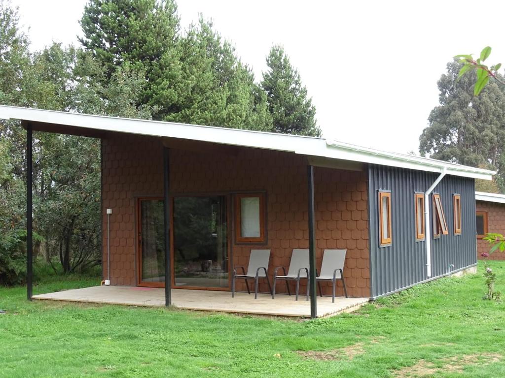 a small house with a deck and chairs on it at CasaMisur in Puerto Varas