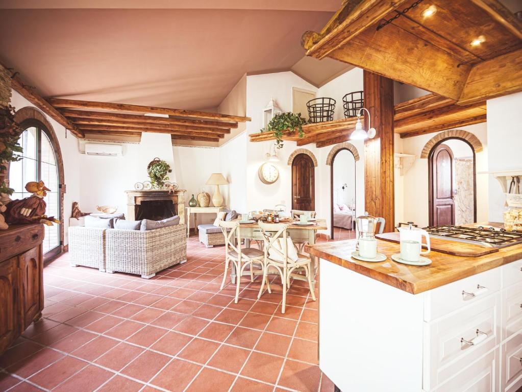 cocina y sala de estar con mesa y sillas en Relais Casale Il Poggetto - OLIVO 1, en Cecina