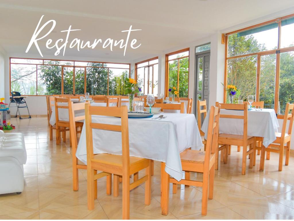 ChachagüíHOTEL PANORAMA SOL的一间配备有白色桌椅的用餐室