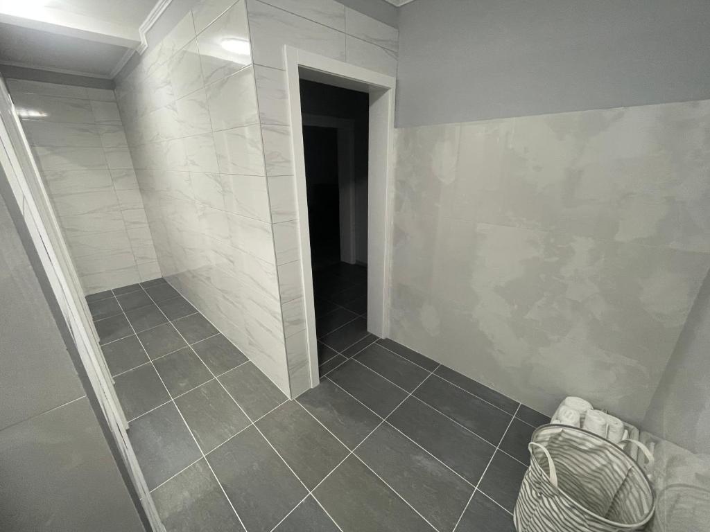ein Bad mit ebenerdiger Dusche und Fliesenboden in der Unterkunft Apartmani Franciska in Jajce