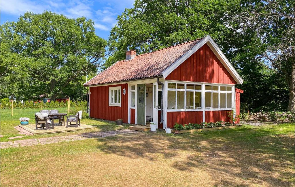 Une grange rouge avec une table de pique-nique dans une cour dans l'établissement Amazing Home In Frjestaden With Kitchen, à Färjestaden