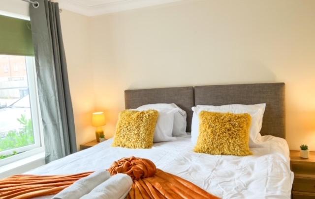 a bedroom with a large bed with yellow pillows at Turners Court in Melksham