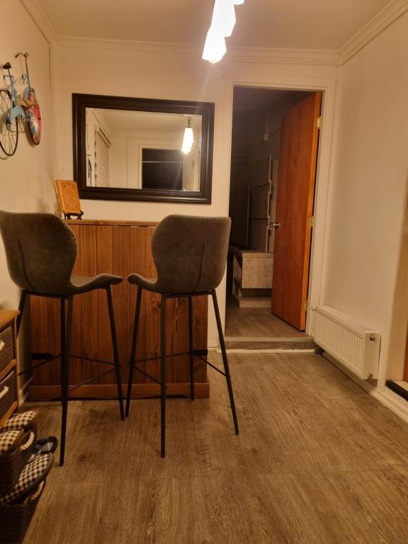 2 sillas sentadas en una habitación con espejo en feelings, en Punta Arenas