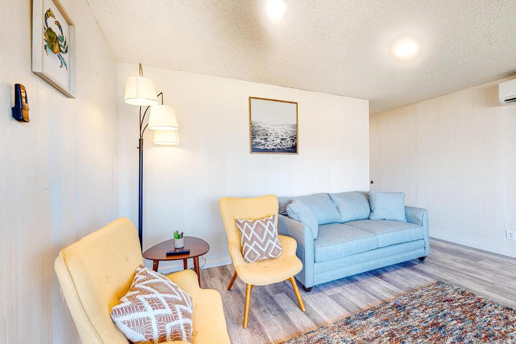 a living room with a blue couch and chairs at Cape Cod Cottages - Unit 9 in Waldport